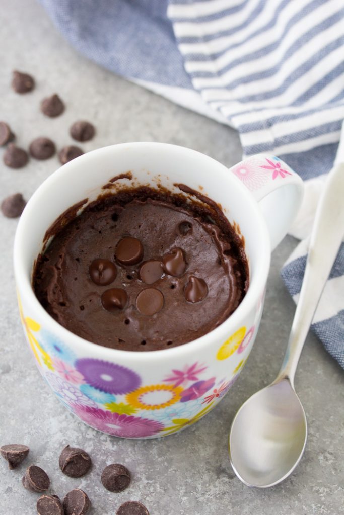 An easy chocolate mug cake that tastes like a brownie in a cup. This chocolate cake in a mug is a delicious microwave dessert that even a kid can make! This recipe has no egg and cooks in just 1 minute! Chocolate mug cake in a flower mug with chocolate chips